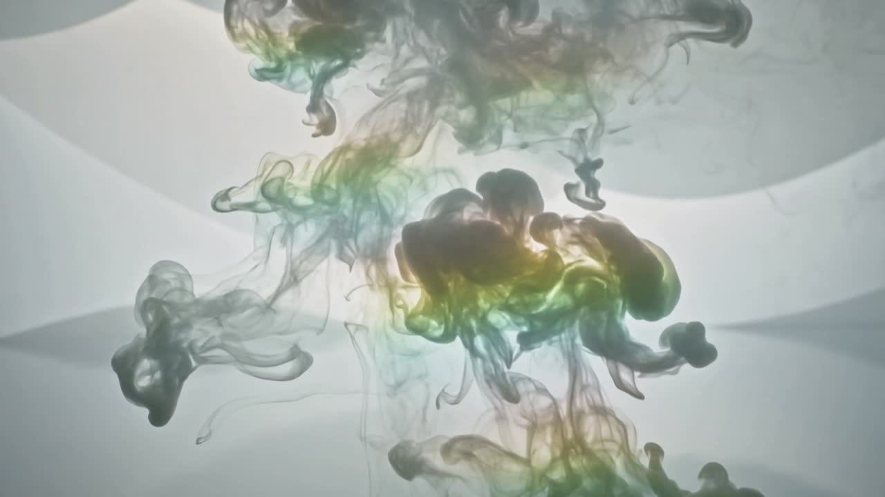 Injecting dye driving plume moving into clear tank, forming colorful cloud with backlit panels