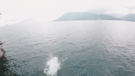 Persona-Buceando-En-El-Lago-Atitlán-En-Un-Día-Nublado,-Vista-Aérea-Fpv