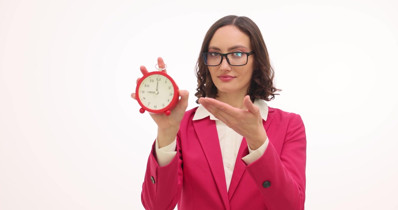 Donna con gli occhiali tiene una sveglia rossa che indica una scadenza.