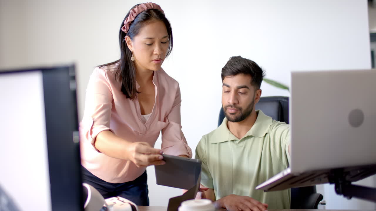 Collaborating in office, colleagues using tablet and laptop for project work