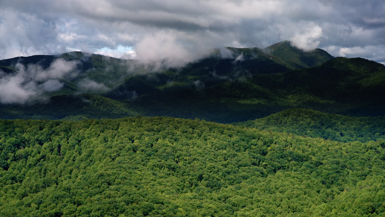 Moody drone view of smoky ridges as clouds and fog converge