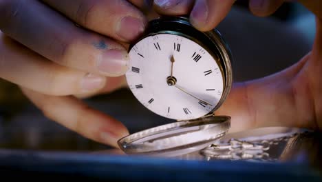 Hand-gently-pulls-up-Anitque-pocket-watch