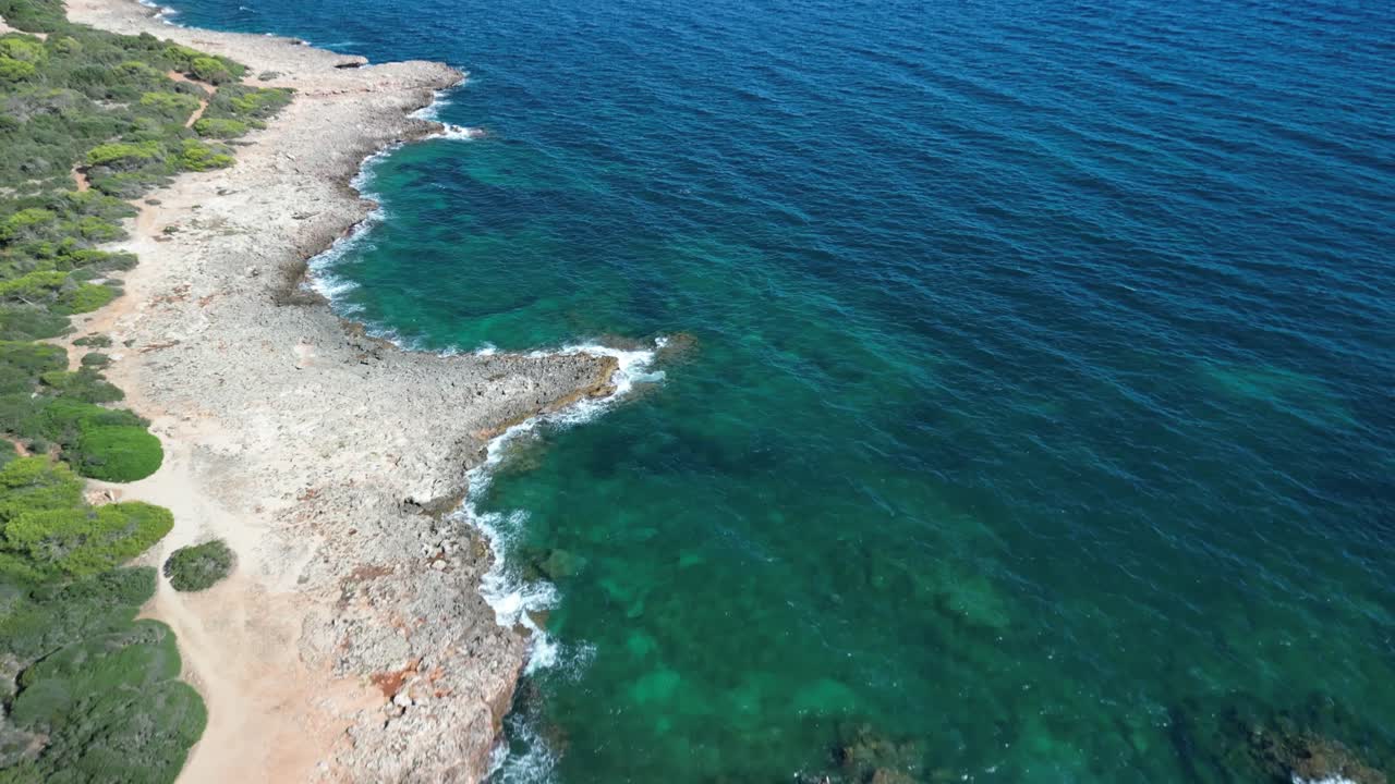 vista serena de un mar y las olas que se estrellan suavemente en la orilla rocosa cerca de sa coma, mallorca, españa