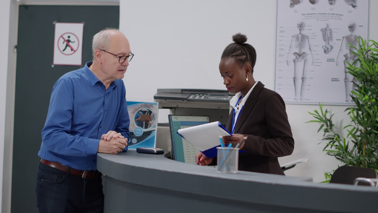 Patient checking in at hospital reception desk with receptionist