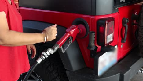 Mujer-Alimentando-Su-Camioneta-Roja-En-La-Gasolinera