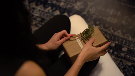 mujer joven desenvolviendo un regalo en la mañana de navidad en cámara lenta