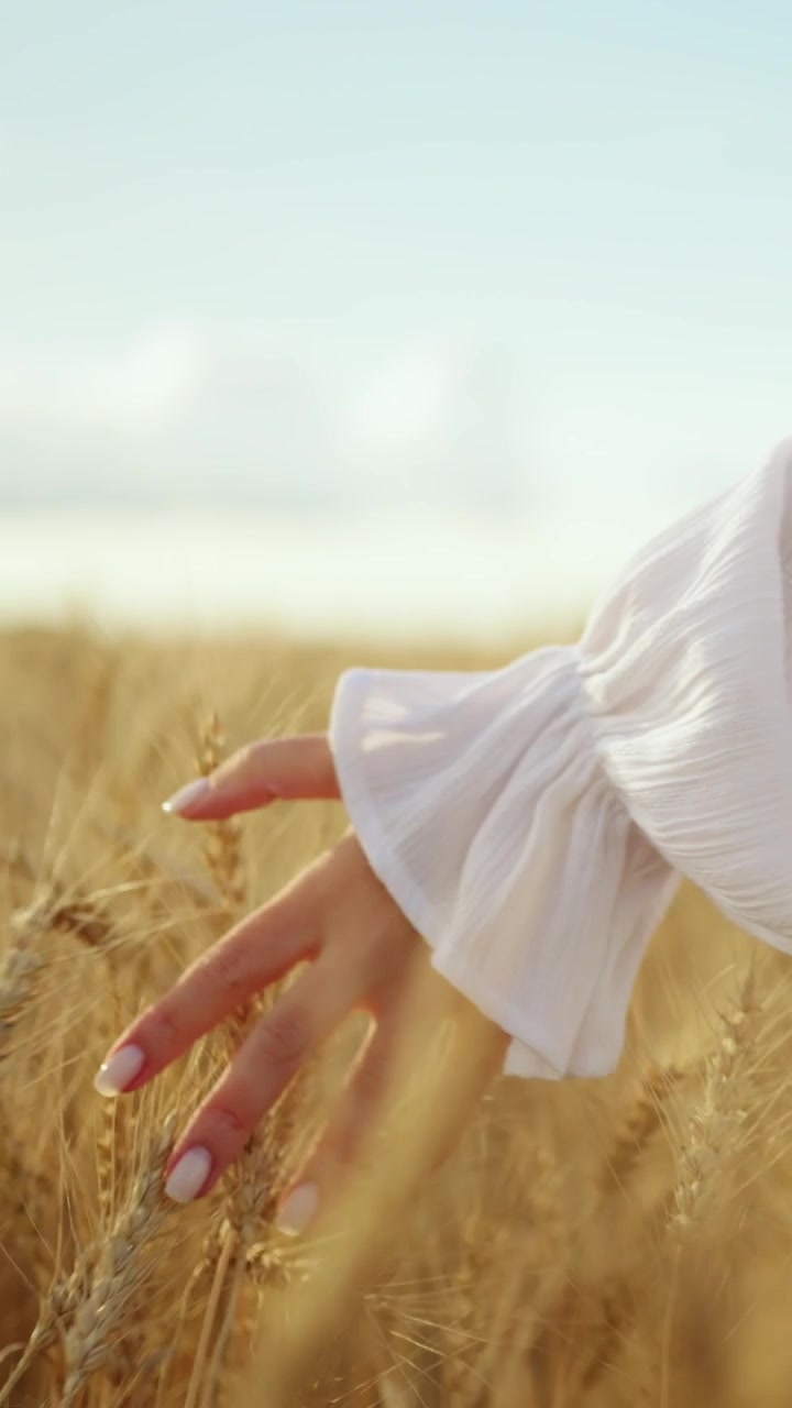 Donna che tocca il grano dorato in un campo soleggiato