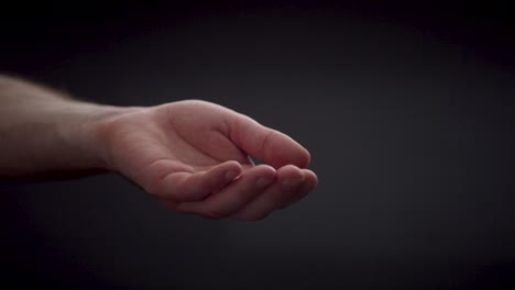 open caucasian hand isolated on black background, gesture of helping hand