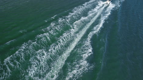 motorboat speeding through the calm sea of ​​a lagoon. sea waves as a tourist boat passes by.