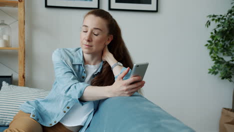 mujer usando teléfono inteligente en el sofá