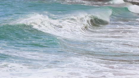 dynamic ocean waves crash against the shore at port campbell, captured in bright, natural lighting with a steady camera