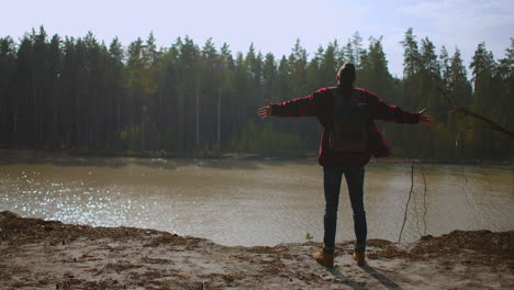 free happy young hiker man in green raincoat looking up with raised arms enjoying calm rainy day in the nature breathing fresh air hair blowing in wind people mountains freedom concept happiness. high quality 4k footage