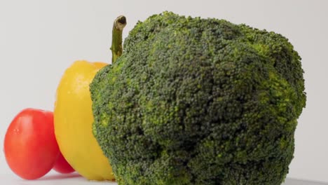 rotando o girando frutas y verduras frescas sobre fondo blanco