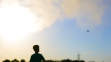 kid playing with flying paper plane. cute boy throwing a paper airplane into the sky in grass
