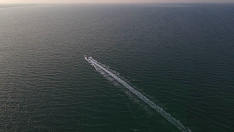 aerial shot of a long-tailed speedboat going towards the arabian sea