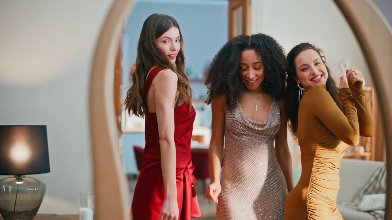 Des amies proches dansent chez elles en se regardant ensemble dans le miroir. Trois femmes souriantes.