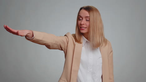 woman in beige jacket pointing