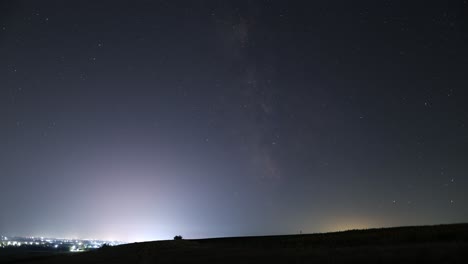 espectacular lapso de tiempo de la vía láctea junto a una ciudad por la noche