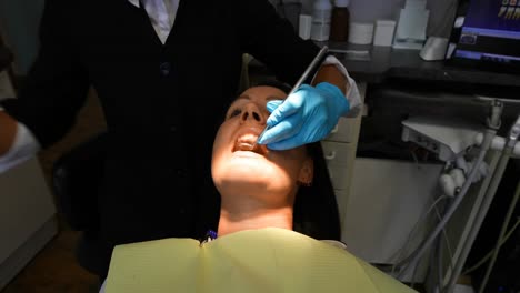 female dentist examining a patient with tools 4k