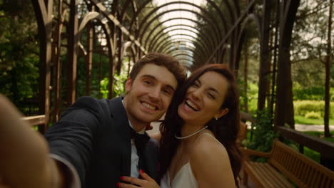 Joyful-man-and-woman-doing-selfie-outdoors.-Couple-smiling-on-camera-in-park