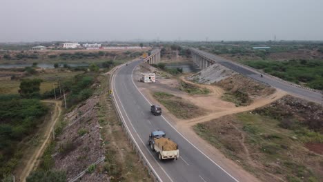 highway and road bridges built over river basin in the rural terrain, aerial view, slow motion