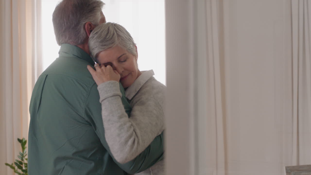 feliz pareja madura bailando en casa disfrutando de un baile romántico juntos celebrando el hito de la relación teniendo una jubilación pacífica 4k