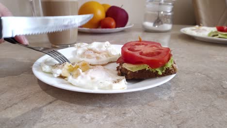 start eating home breakfast fried eggs with sandwich, tomatos, salad, bread and coffee