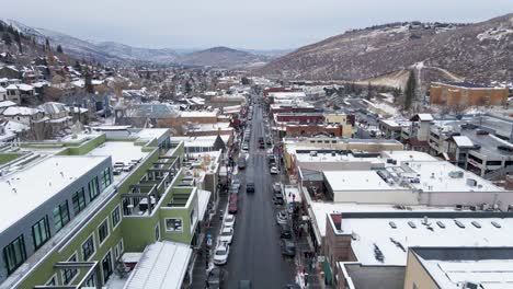 Beautiful-View-Of-Park-City-Mainstreet-In-Western-State-Of-Utah-Surrounded-With-Buildings-And-Background-With-High-Mountains-During-Daytime---Aerial-Shot