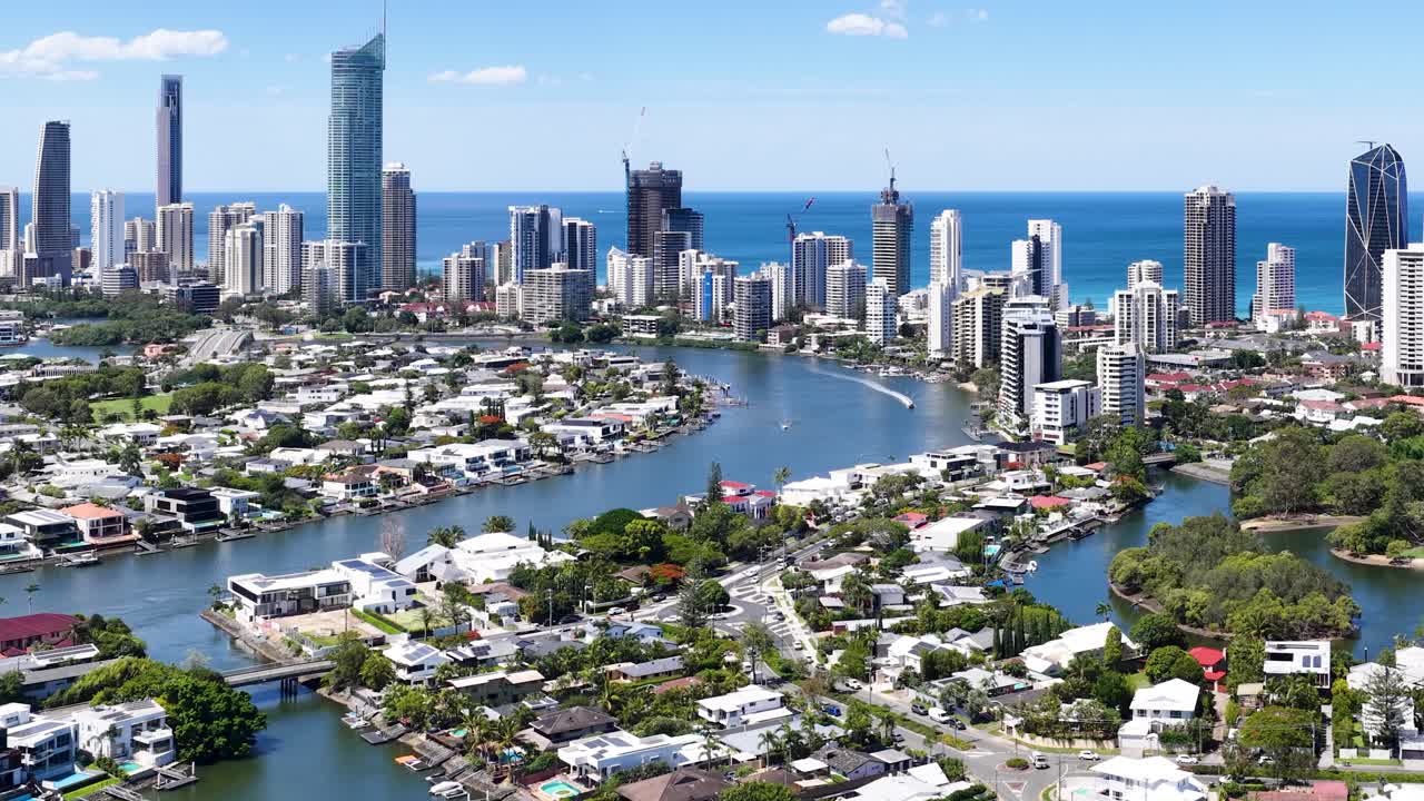 Daytime drone footage glides over Broadbeach Waters, revealing city skyline, canals, and coastline