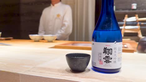 sake bottle and cup on a restaurant counter