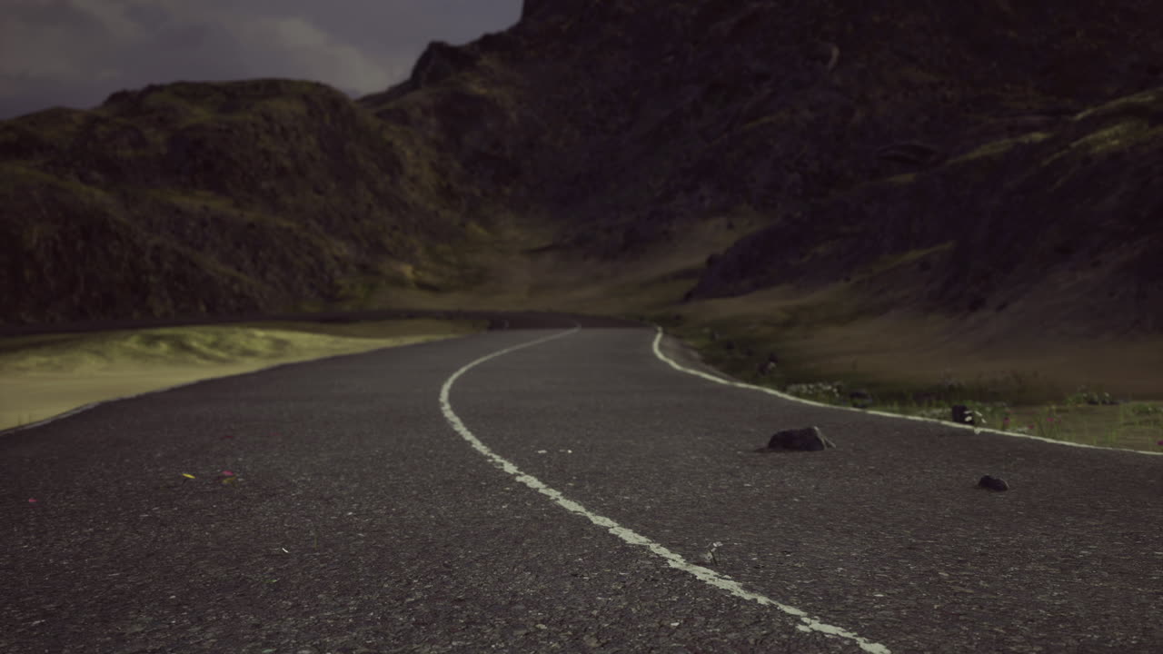 Serene winding road through rugged mountains under a cloudy sky