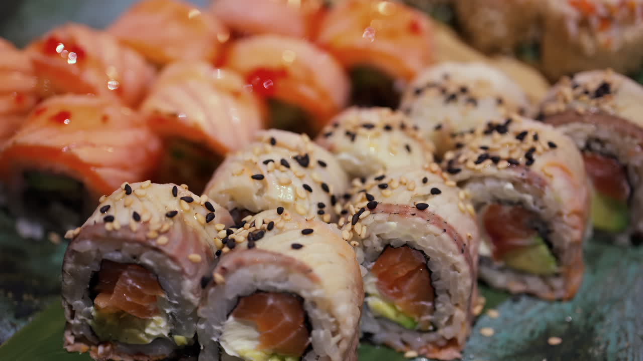 Close up of Philadelphia and California sushi rolls on a platter at a restaurant