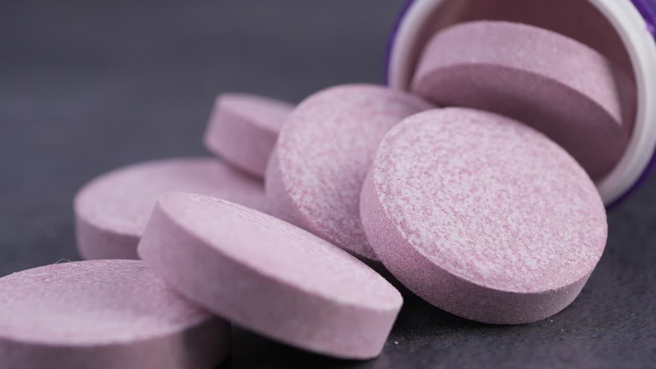 Pink Effervescent Tablets Spilling from a Medicine Bottle