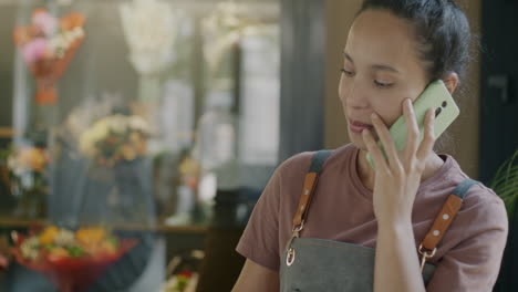 florist talking on phone and working on laptop