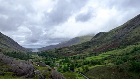 A-small-flock-of-sheep-are-startled-while-grazing-in-a-lush-green-rocky-valley