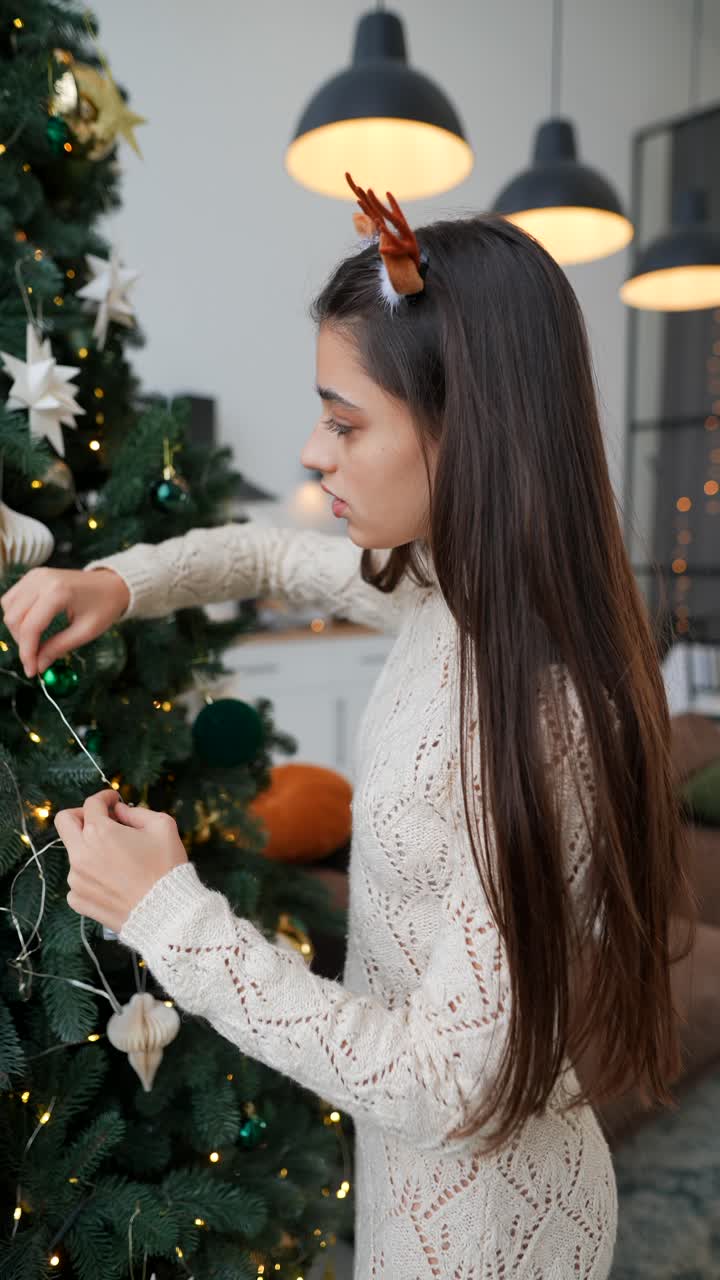 una adolescente decorando el árbol de navidad