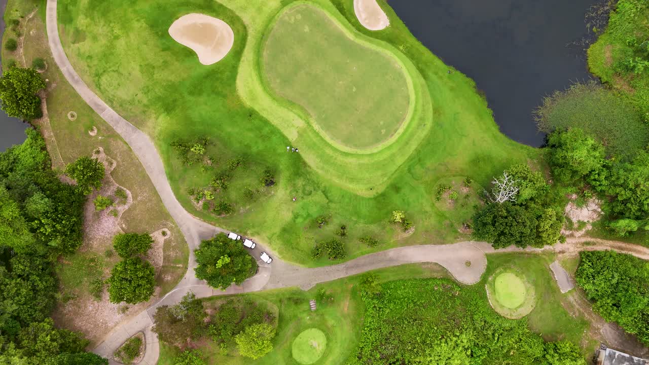 드론 영상은 태국 푸켓의 울창한 골프 코스를 포착합니다. 활기찬 그린, 모래 커, 그리고 조용한 물 특징을 보여줍니다.