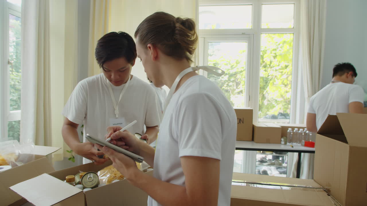 Volunteers Collecting Box with Products for Donation