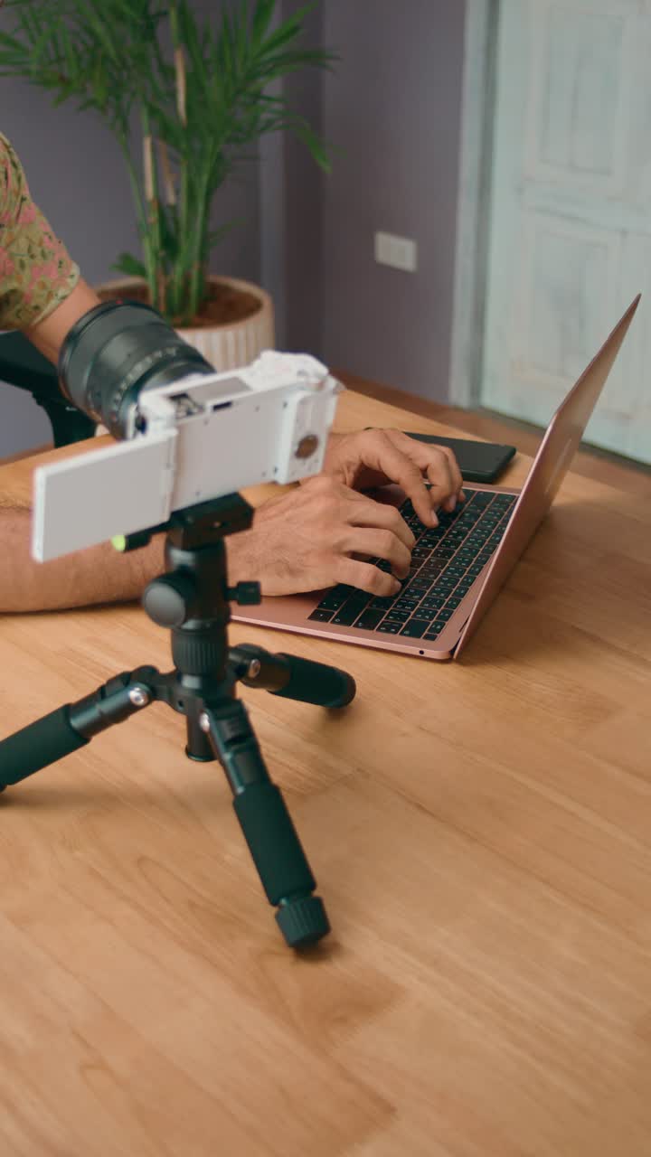 Person Recording Video on Laptop with Camera on Tripod