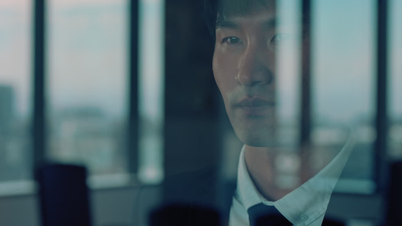 empresario asiático exitoso mirando por la ventana orgulloso director general planeando con anticipación pensando en ideas para la futura estrategia de inversión gerente corporativo disfrutando de la carrera de liderazgo en la oficina