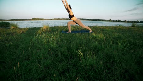 young girl doing yoga moves on green grass. woman practicing yoga in morning