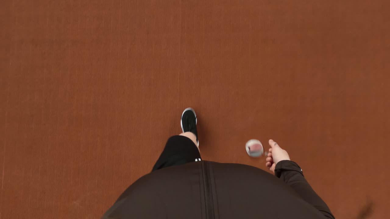 Overhead view of a person walking on an athletic track