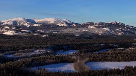 winter nature scene of lake laberge with forests and mountain in yukon, canada. aerial drone shot