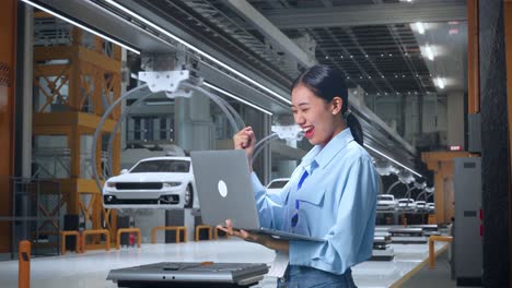 woman celebrating success in a modern car factory
