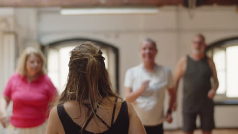 Back-view-of--female-dance-teacher-showing-moves-to-group