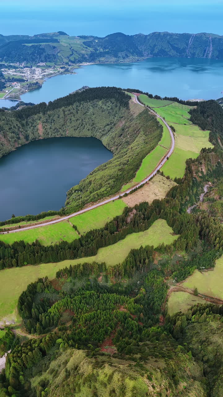 Flight over the mount approaching the lake in volcano crater. Amazing scenery of the Azorean Islands from top. Vertical video.