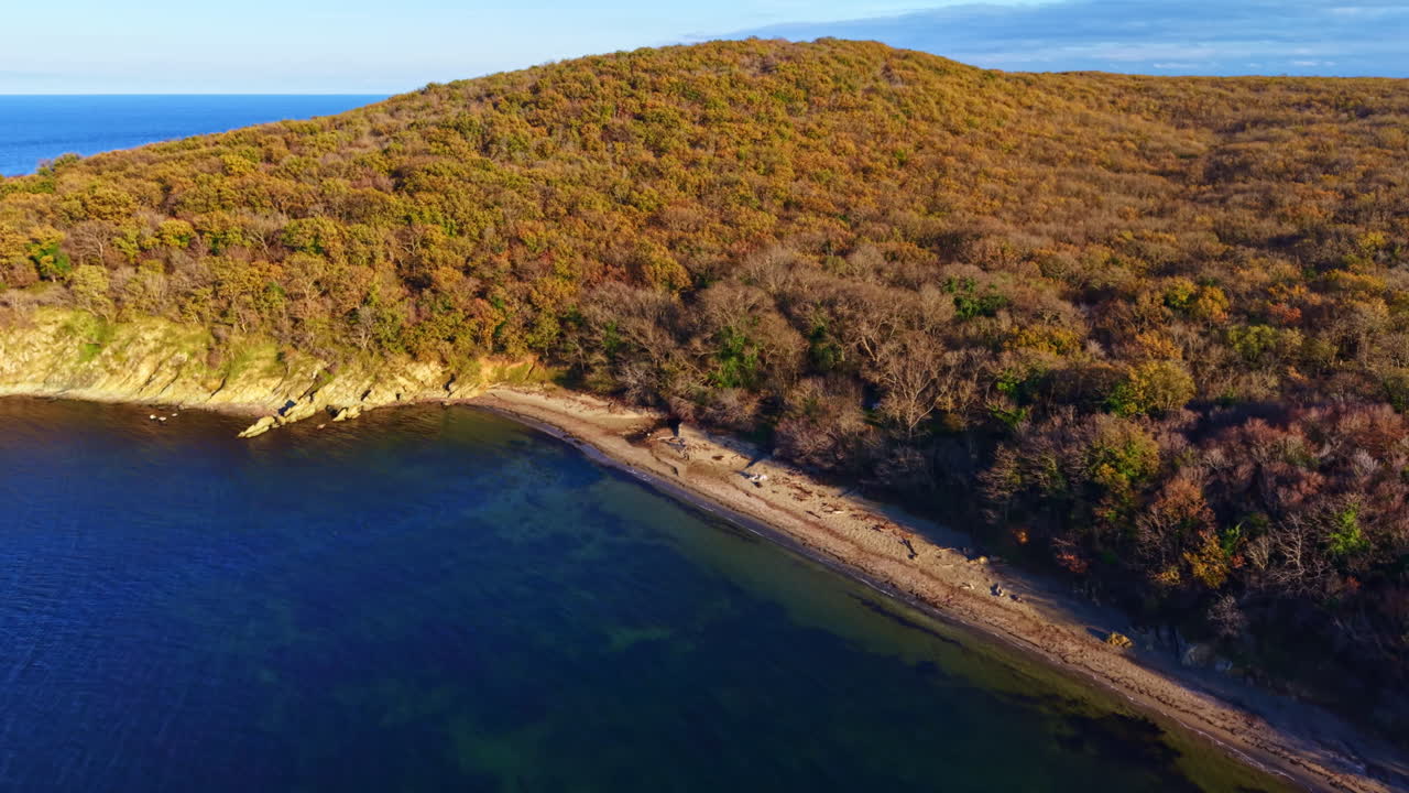 Klidné jezero obklopené podzimními kopci odráží klidnou oblohu při západu slunce v prostředí mírumilovné přírody
