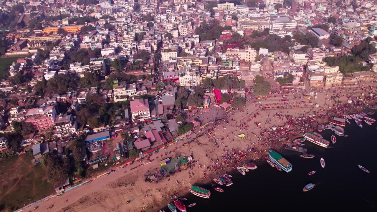buildings with varanasi ghats and parked boats at day time, pan shot, drone shot, 4k.