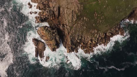aerial view of rugged rocky coastline with crashing waves