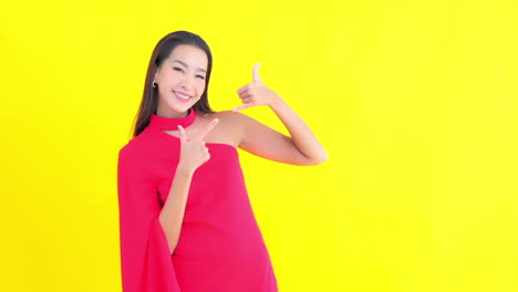 asian woman dressed in red makes phone calling gesture